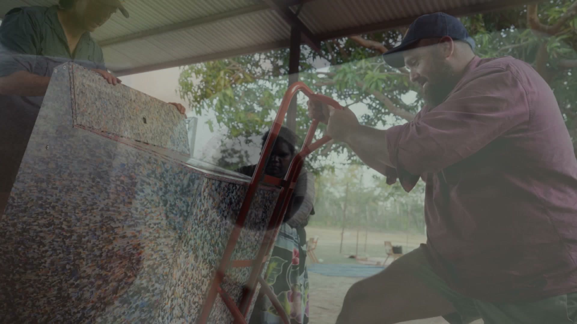 Maningrida, July 2026 — Lifting a pressed panel.