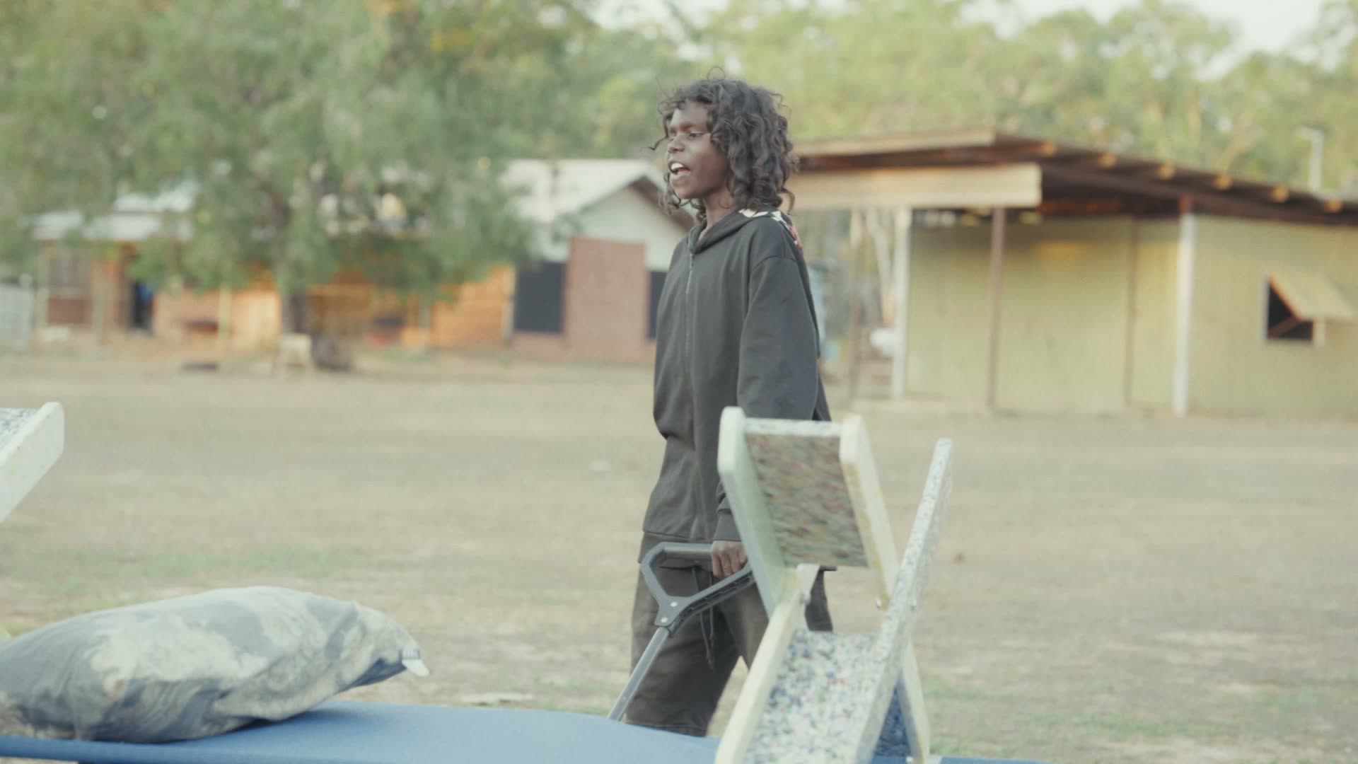 Maningrida, July 2026 — Carrying a bed across the community.